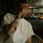 tattooed man smoking a cigarette