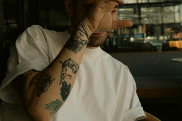 tattooed man smoking a cigarette